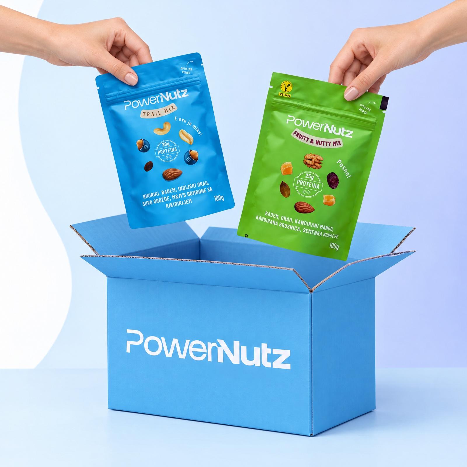 Dve ruke spuštaju kesice Trail mixa i Fruity and Nutty mixa u plavu PowerNutz kutiju